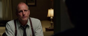 Movie still from “The Highwaymen” (2019), directed by John Lee Hancock – A man sitting in front of a lamp in a living room; Close Up shot, Over the shoulder angle