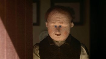 Movie still from “The House” (2022), directed by Paloma Baeza – A man with blue eyes is standing next to a door; Close Up shot, Over the shoulder angle