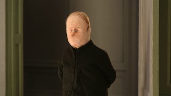 Movie still from “The House” (2022), directed by Paloma Baeza – A doll wearing a black outfit with a white face; Close Up shot, High angle