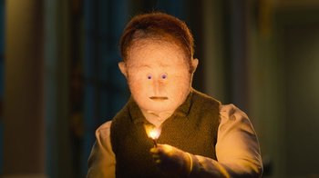 Movie still from “The House” (2022), directed by Paloma Baeza – A child with a candle in his hand; Close Up shot, High angle