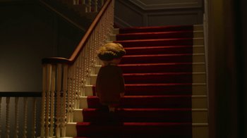 Movie still from “The House” (2022), directed by Paloma Baeza – A stuffed doll standing at the top of a set of stairs; Wide shot, Low angle