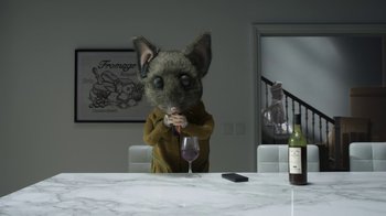 Movie still from “The House” (2022), directed by Paloma Baeza – A cat sitting at a table with a glass of wine; Wide shot, High angle