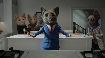 Movie still from “The House” (2022), directed by Paloma Baeza – A mouse dressed in a suit and tie holding a cell phone; Wide shot, Low angle