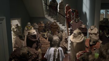 Movie still from “The House” (2022), directed by Paloma Baeza – A group of people dressed in animal costumes in front of a staircase; Wide shot, High angle