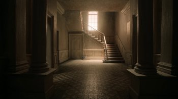 Movie still from “The House” (2022), directed by Paloma Baeza – A room with a staircase and a window; Extreme Wide shot, Low angle