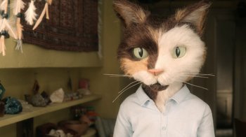 Movie still from “The House” (2022), directed by Paloma Baeza – A person with a cat head in a room; Close Up shot, Over the shoulder angle