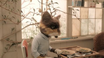 Movie still from “The House” (2022), directed by Paloma Baeza – A cat wearing a blue shirt and white gloves; Medium shot, High angle
