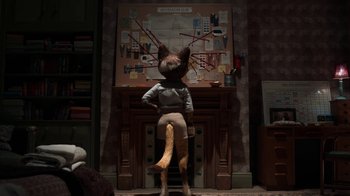 Movie still from “The House” (2022), directed by Paloma Baeza – A person sitting on top of a chair with a cat head on it; Medium shot, Over the shoulder angle
