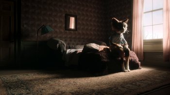 Movie still from “The House” (2022), directed by Paloma Baeza – A cat sitting on top of a bed next to a window; Wide shot, High angle
