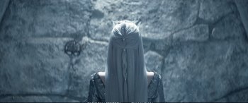 Movie still from “The Huntsman: Winter's War” (2016), directed by Cedric Nicolas-Troyan – A woman with long white hair is standing in front of some rocks; Close Up shot, Over the shoulder angle