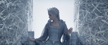 Movie still from “The Huntsman: Winter's War” (2016), directed by Cedric Nicolas-Troyan – A woman dressed as a snow queen standing in front of pillars; Medium shot, Low angle