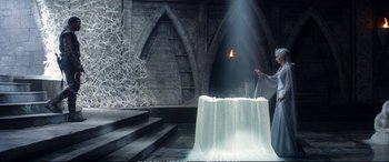 Movie still from “The Huntsman: Winter's War” (2016), directed by Cedric Nicolas-Troyan – A man standing in front of a table with a candle; Wide shot, Low angle