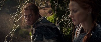 Movie still from “The Huntsman: Winter's War” (2016), directed by Cedric Nicolas-Troyan – A person wearing a jacket near a tree; Medium shot, Over the shoulder angle
