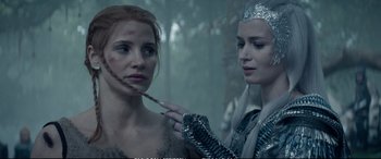 Movie still from “The Huntsman: Winter's War” (2016), directed by Cedric Nicolas-Troyan – A woman is painting another woman's face with a brush; Close Up shot, Over the shoulder angle