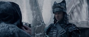 Movie still from “The Huntsman: Winter's War” (2016), directed by Cedric Nicolas-Troyan – A man in a costume standing in front of a building; Close Up shot, Over the shoulder angle