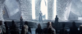 Movie still from “The Huntsman: Winter's War” (2016), directed by Cedric Nicolas-Troyan – A group of people sitting on steps in front of a stage; Wide shot, High angle