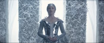Movie still from “The Huntsman: Winter's War” (2016), directed by Cedric Nicolas-Troyan – A woman dressed as a snow queen standing in front of a window; Medium shot, Low angle