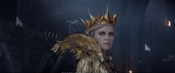 Movie still from “The Huntsman: Winter's War” (2016), directed by Cedric Nicolas-Troyan – A woman wearing a gold crown and a gold jacket; Close Up shot, Over the shoulder angle