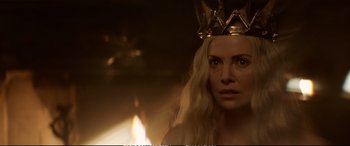 Movie still from “The Huntsman: Winter's War” (2016), directed by Cedric Nicolas-Troyan – A woman wearing a gold crown in front of a fire pit; Close Up shot, Over the shoulder angle