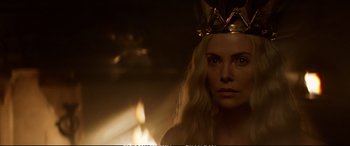 Movie still from “The Huntsman: Winter's War” (2016), directed by Cedric Nicolas-Troyan – A woman wearing a gold crown in front of a fire; Close Up shot, Over the shoulder angle