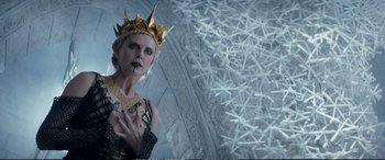 Movie still from “The Huntsman: Winter's War” (2016), directed by Cedric Nicolas-Troyan – A woman in a crown and a necklace is standing in front of a wall; Close Up shot, Low angle