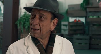 Movie still from “The Irishman” (2019), directed by Martin Scorsese – An older man wearing a hat and a scarf; Close Up shot, Over the shoulder angle