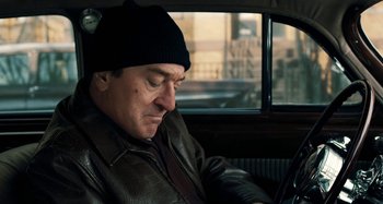 Movie still from “The Irishman” (2019), directed by Martin Scorsese – A man sitting in the back seat of a car; Close Up shot, Over the shoulder angle