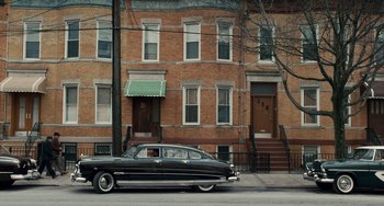 Movie still from “The Irishman” (2019), directed by Martin Scorsese – An old car parked on the side of the street; Extreme Wide shot, High angle