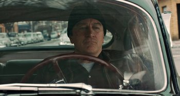 Movie still from “The Irishman” (2019), directed by Martin Scorsese – A man sitting in the driver's seat of a car; Close Up shot, Over the shoulder angle