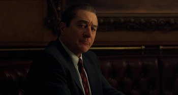 Movie still from “The Irishman” (2019), directed by Martin Scorsese – A person wearing a suit and tie; Close Up shot, Over the shoulder angle