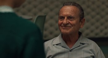 Movie still from “The Irishman” (2019), directed by Martin Scorsese – An older man is smiling while sitting in a chair; Close Up shot, Over the shoulder angle