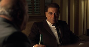 Movie still from “The Irishman” (2019), directed by Martin Scorsese – A man sitting at a table holding a bottle of beer; Close Up shot, Over the shoulder angle