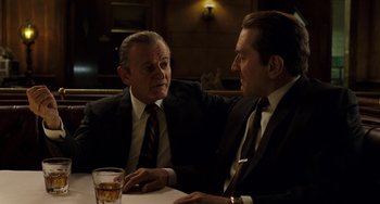 Movie still from “The Irishman” (2019), directed by Martin Scorsese – Two men sitting at a table talking to each other; Medium shot, Over the shoulder angle