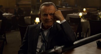 Movie still from “The Irishman” (2019), directed by Martin Scorsese – An older man sitting at a table in a restaurant; Close Up shot, Over the shoulder angle