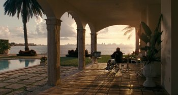 Movie still from “The Irishman” (2019), directed by Martin Scorsese – A man sitting on a chair on a porch near the ocean; Extreme Wide shot, Over the shoulder angle