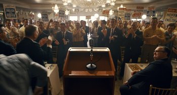 Movie still from “The Irishman” (2019), directed by Martin Scorsese – A crowd of people in suits and ties clapping at a podium; Wide shot, High angle