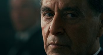 Movie still from “The Irishman” (2019), directed by Martin Scorsese – An older man looking into the distance with a serious look; Close Up shot, Over the shoulder angle