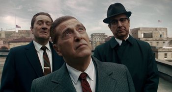 Movie still from “The Irishman” (2019), directed by Martin Scorsese – A group of men standing next to each other in front of a building; Medium shot, Low angle