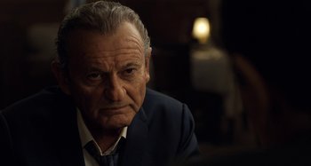 Movie still from “The Irishman” (2019), directed by Martin Scorsese – An older man wearing a suit and tie; Close Up shot, Over the shoulder angle
