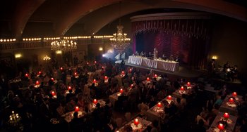 Movie still from “The Irishman” (2019), directed by Martin Scorsese – People are sitting at tables in front of a stage; Extreme Wide shot, High angle