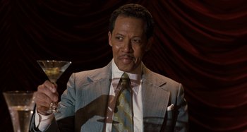 Movie still from “The Irishman” (2019), directed by Martin Scorsese – A man wearing a suit and tie with a martini glass in front of him; Close Up shot, High angle