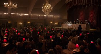 Movie still from “The Irishman” (2019), directed by Martin Scorsese – A group of people sitting at tables in front of a chandelier; Extreme Wide shot, High angle