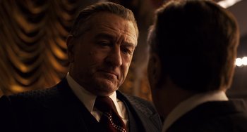 Movie still from “The Irishman” (2019), directed by Martin Scorsese – A man in a suit talking to another man; Close Up shot, Over the shoulder angle