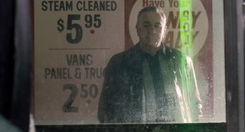 Movie still from “The Irishman” (2019), directed by Martin Scorsese – A man standing in front of a store window; Medium shot, Low angle