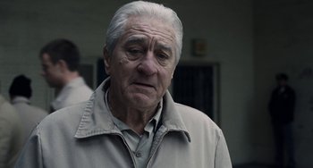 Movie still from “The Irishman” (2019), directed by Martin Scorsese – An old man with a gray hair and a gray jacket; Close Up shot, Low angle