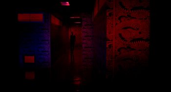 Movie still from “Only God Forgives” (2013), directed by Nicolas Winding Refn – A person is standing in a dark hallway; Extreme Wide shot, Over the shoulder angle