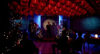 Movie still from “Only God Forgives” (2013), directed by Nicolas Winding Refn – A man standing on a stage in front of red lanterns; Extreme Wide shot, Over the shoulder angle