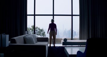 Movie still from “Only God Forgives” (2013), directed by Nicolas Winding Refn – A woman standing in front of a large window looking out at a city; Wide shot, Low angle
