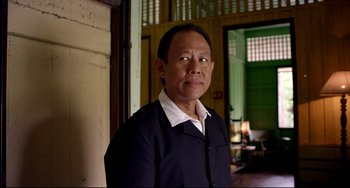 Movie still from “Only God Forgives” (2013), directed by Nicolas Winding Refn – A man standing in front of an open door; Medium shot, Low angle