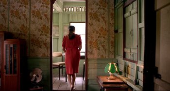 Movie still from “Only God Forgives” (2013), directed by Nicolas Winding Refn – A woman in a red dress standing in front of a window; Wide shot, High angle
